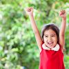Little girl raises her hand high and happy