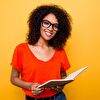 Young lady smiling and holding a book in her hand
