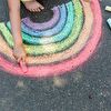 Child drawing rainbow to the ground