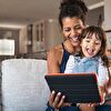 Mother and daughter using tablet and smiling