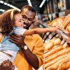 Daughter pointing out the bread while her father holds in his arms