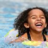 Little girl swimming in a pool and laughing