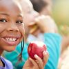 Girl eating apple and smiling