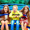 Group of children sitting on playground climber and smiling