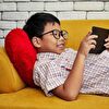 Boy With Large Eyeglasses Entertained by Smartphone