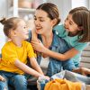 Daughters Hugging Mother While Doing Housework