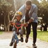 Father Assisting Son Learn Cycling