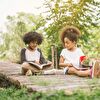 Girl and Boy Sitting on Wooden Pavement With Books