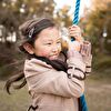 Girl in Jacket Strongly Holding Swing Rope