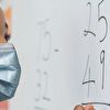 Girl wearing mask and writing to the white board