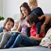 Mother With Three Kids Reading Storybook